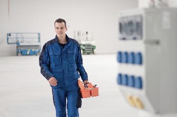 Bilde av en elektriker som går ut av et lokale
