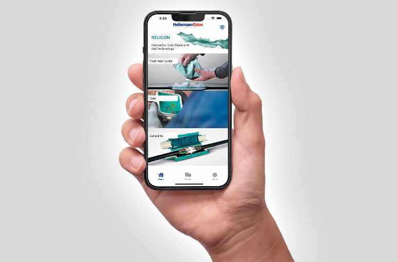 En hånd som holder en mobiltelefon innlogget med ReliCon kabelskjøt App