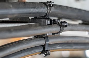 EdgeClip HDEC kantklips kombinert med tre strips for parallellføring av tre kabler rundt en tykk ramme