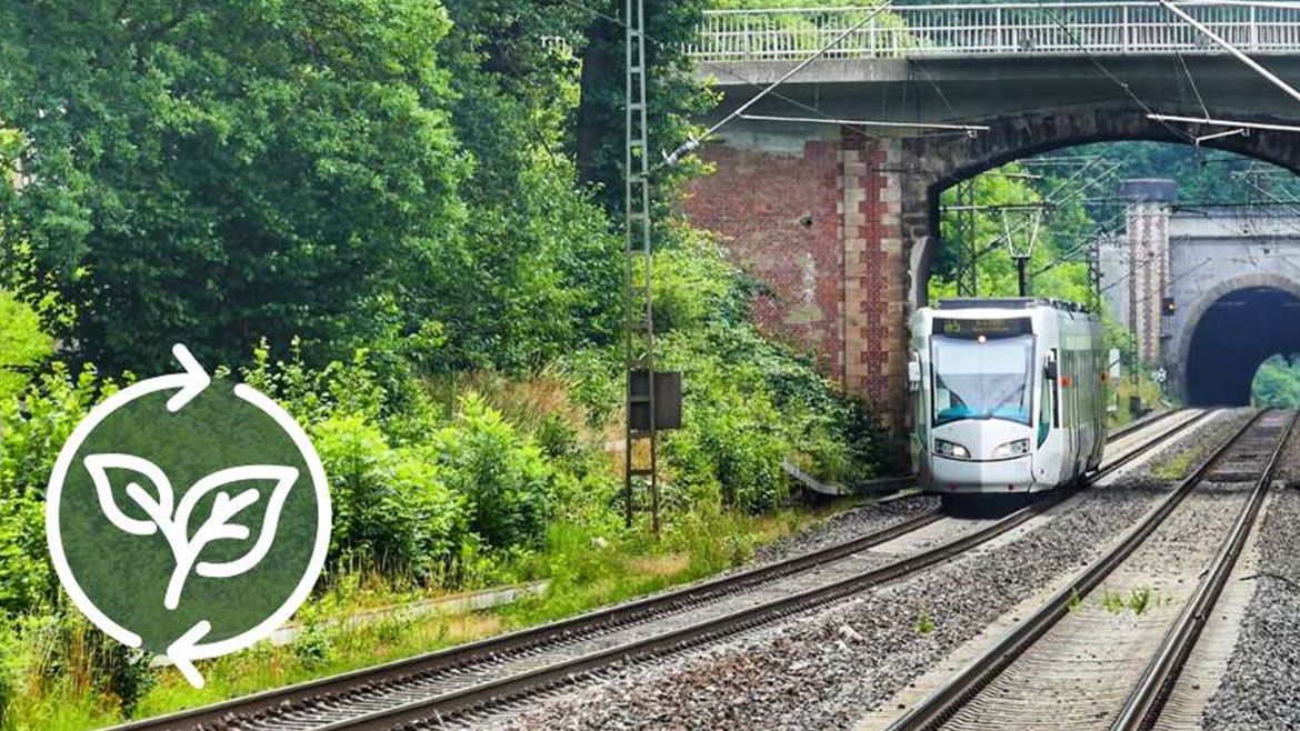 Et tog som kjører på togskinner mot en bærekraft logo